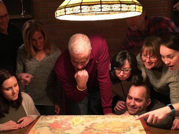Solve puzzles indoors, with your friends - A family thinking over a puzzle in an escape room